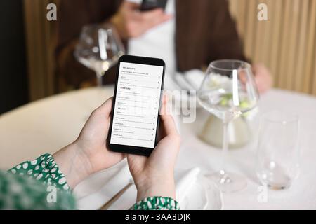 Couple choisissant des plats à partir du menu numérique au restaurant, gros plan Banque D'Images