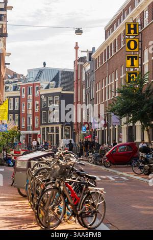 Une scène de rue classique d'Amsterdam avec des vélos garés devant des bâtiments hollandais traditionnels, capturant l'essence du charme de la ville Banque D'Images