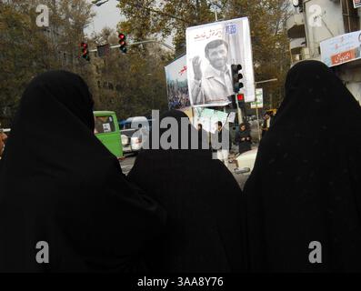 14 décembre 2006 - Téhéran, IRAN - des femmes iraniennes passant devant de grandes bannières du président iranien Mahmoud Ahmadinejad sur la place Valiasr de Téhéran. Les élections municipales iraniennes et les élections de l'Assemblée des experts se tiendront simultanément le 15 décembre. Photo de Siavash Habibollahi/ZUMA Press. Banque D'Images