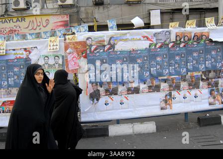 14 décembre 2006 - Téhéran, IRAN - des femmes iraniennes passent devant les affiches des candidats municipaux de Téhéran sur la place Enqelab. Les élections municipales iraniennes et les élections de l'Assemblée des experts se tiendront simultanément le 15 décembre. Photo de Siavash Habibollahi/ZUMA Press. Banque D'Images