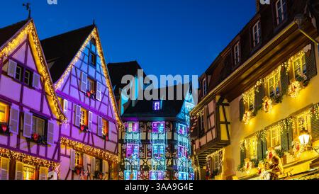 Colmar, France - 28 novembre 2024 : maisons à colombages colorées à Colmar, Alsace, décorées de lumières de Noël au crépuscule. Banque D'Images