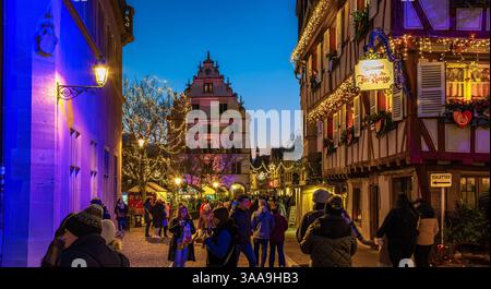 Colmar, France - 28 novembre 2024 : une scène de rue festive à Colmar, Alsace, pendant la soirée, avec des gens marchant et des bâtiments ornés de Chris Banque D'Images