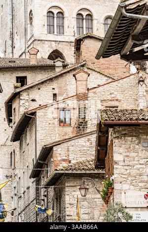 Une rangée de maisons dans la ville de Gubbio en Italie Ombrie avec une fenêtre au milieu. Les maisons sont en pierre et ont un aspect rustique. Les maisons le sont Banque D'Images