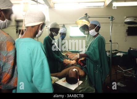 01 août 1992 ; Mogadiscio, SOMALIE ; des hommes opèrent une victime d’une blessure par balle à l’estomac à l’hôpital Dikfer à Mogadiscio. Les hommes sont des étudiants en médecine, apprenant sur le tas, puisque la plupart des médecins et autres professionnels ont fui le pays au début de la guerre civile. Ils n'ont pas d'anesthésique et doivent utiliser la katamine, une dissociation, pendant la chirurgie. Crédit obligatoire : photo de Cheryl Hatch/ZUMA Press. (©) Copyright 1992 par Cheryl Hatch Banque D'Images