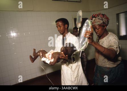 01 août 1992 ; Mogadiscio, SOMALIE ; Un garçon transporte une fillette de 18 mois blessée par balle à l’estomac à la salle d’opération de l’hôpital Dikfer à Mogadiscio. Crédit obligatoire : photo de Cheryl Hatch/ZUMA Press. (©) Copyright 1992 par Cheryl Hatch Banque D'Images