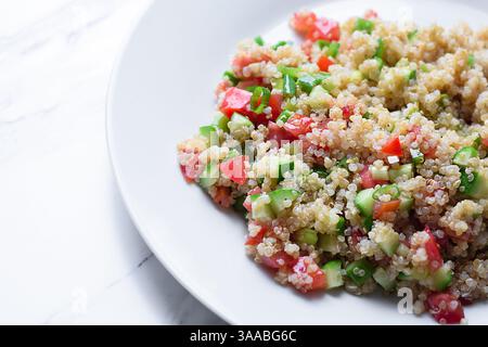 Salade de quinoa saine avec des légumes frais sur une assiette blanche en gros plan Banque D'Images