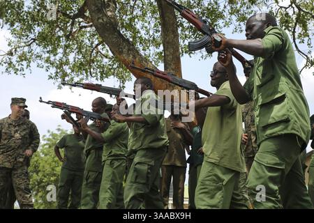 Le 3 mars 2015 - Matambwe, Tanzanie - Un Marine américain de la Force opérationnelle aérienne-terrestre spéciale Marine Response-Africa aide les gardes forestiers tanzaniens à effectuer des exercices de rechargement de vitesse lors d'une classe de tir au combat à la réserve de gibier Selous le 3 mars 2015 à Matambwe, en Tanzanie. Les Marines enseignent aux gardes forestiers tanzaniens des compétences d'infanterie telles que la patrouille, les tactiques offensives, la navigation terrestre et les opérations montées pour aider à lutter contre le trafic illicite. (Crédit image : © LCPL. Lucas J. Hopkins/Planet Pix via ZUMA Wire) Banque D'Images