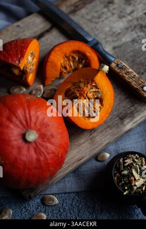 Citrouille orange, couteau et tranches de citrouille hachée sur la table. Capacité avec épices pour la cuisine maison Banque D'Images