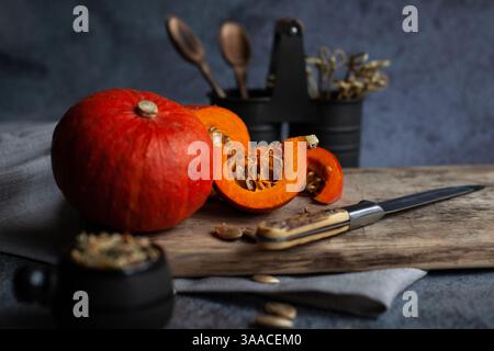Une petite citrouille avant la cuisson se trouve sur le plateau, sur la table de la cuisine. Recettes pour cuisiner des produits naturels à la maison Banque D'Images