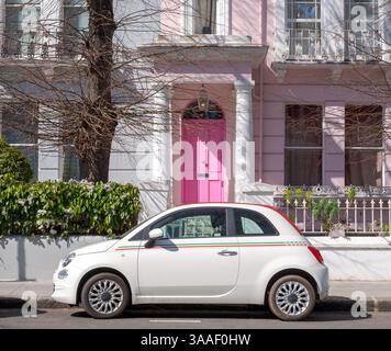 Fiat 500 voiture classique garée devant une maison avec une porte rose dans une rue résidentielle à Notting Hill, ouest de Londres Royaume-Uni. Banque D'Images