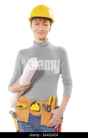 Ouvrière de la construction avec des outils tenant le grand roll up plan regardant la caméra souriant isolé sur fond blanc Banque D'Images