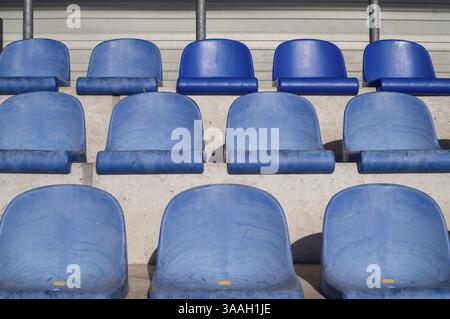 Rangées de sièges en plastique bleu vides dans un stade, attendant l'arrivée de la foule Banque D'Images