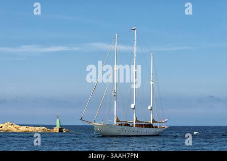 Un yacht à voile de luxe entrant dans un port en Méditerranée en Sardaigne Banque D'Images