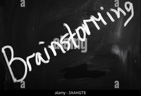 Brainstorming écrit à la main avec de la craie blanche sur un tableau noir Banque D'Images