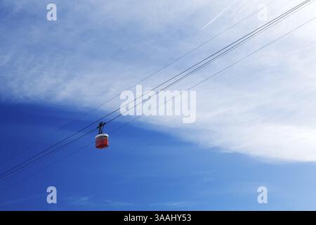 Cabine de téléphérique rouge dans le ciel avec des nuages Banque D'Images
