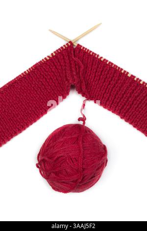 Les aiguilles à tricoter Lives s'enchevêtrent de fil rouge. Artisanat fait main. Isoler sur blanc Banque D'Images
