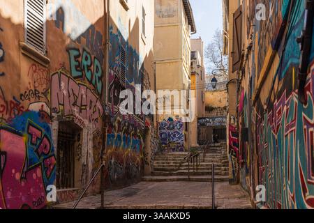 Marsaille, FRANCE - 24 MARS 2025 : des peintures murales colorées ornent les rues étroites et vallonnées du quartier historique de Marsaille le panier. Banque D'Images