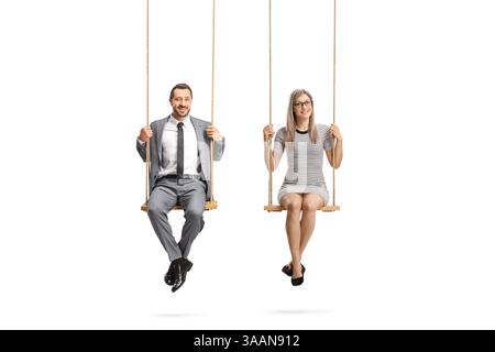 Homme et femme assis sur des balançoires et souriant isolé sur fond blanc Banque D'Images