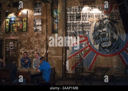 28 septembre 2010 - Berlin, Berlin, Allemagne - Berlin, Allemagne, un deux hommes prennent une bière dans le bar Zapata près du Kunsthaus Tacheles. Le Kunsthaus Tacheles (Art House Tacheles) était un centre d'art à Berlin, en Allemagne, un grand bâtiment (9000 mètres carrés) et parc de sculptures sur Oranienburger StraÃŸe dans le quartier connu sous le nom de Mitte. D'immenses peintures murales colorées de style graffiti sont peintes sur les murs extérieurs, et des sculptures d'art moderne sont présentées à l'intérieur. Le bâtiment abrite un collectif d'artistes qui est menacé d'expulsion..à l'origine appelé ''Friedrichsstadtpassagen'', il a été construit comme un stor de département Banque D'Images
