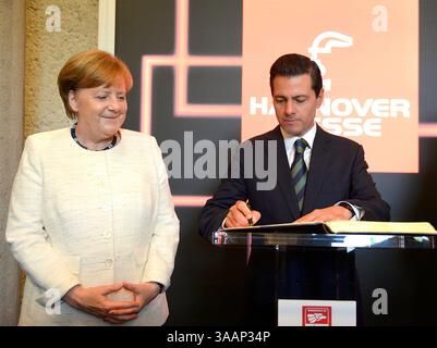22 avril 2018 - Hanovre, ALLEMAGNE - la chancelière allemande Angela Merkel est partie avec le président mexicain Enrique Pena Nieto, alors qu'il signe un livre d'or à la foire Hannover Messe où le Mexique est le pays invité de cette année à Hanovre, dans le nord de l'Allemagne, lundi 23 avril 2018. (Crédit image : © Prensa Internacional via ZUMA Wire) Banque D'Images