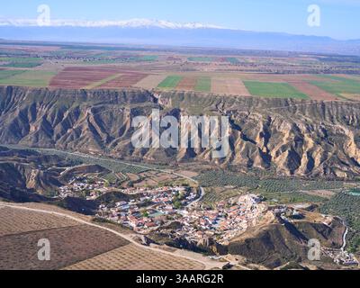 VUE AÉRIENNE. Village isolé de Gorafe. Massif enneigé de la Sierra Nevada au loin. Province de Grenade, Andalousie, Espagne. Banque D'Images
