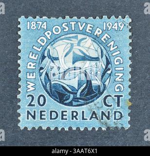Timbre-poste oblitéré imprimé par les pays-Bas, qui montre Globe avec cornes postales, 75ème anniversaire de l'Union postale universelle (U.P.U.), vers 1949. Banque D'Images