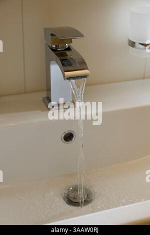 De l'eau claire s'écoule du robinet. Banque D'Images