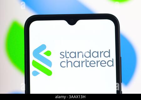 Dans cette illustration photo, le logo Standard Chartered est affiché sur l'écran d'un smartphone. Banque D'Images
