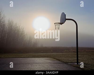 Un basket sur un terrain vide dans un parc près du lever du soleil dans le nord de l'Idaho. Banque D'Images