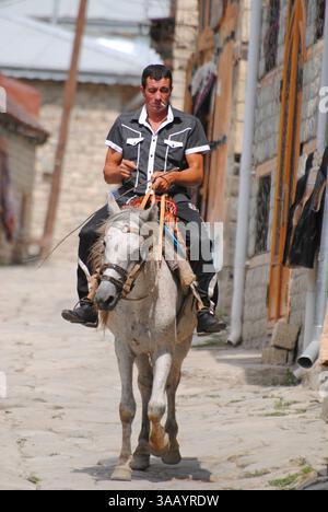 Lahic, Azerbaïdjan - 30 août, 2014. Horse Rider sur la rue principale de Lahic village montagneux de l'Azerbaïdjan. Banque D'Images