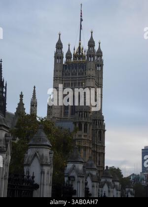 Une vue sur un bâtiment historique à l'architecture complexe, avec une grande tour surmontée d'un drapeau. La scène est placée contre un ciel nuageux, avec arbre Banque D'Images