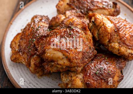 Cuisses de poulet rôties ou frites à l'air avec du paprika, des épices frottent et du citron vert sur une assiette Banque D'Images