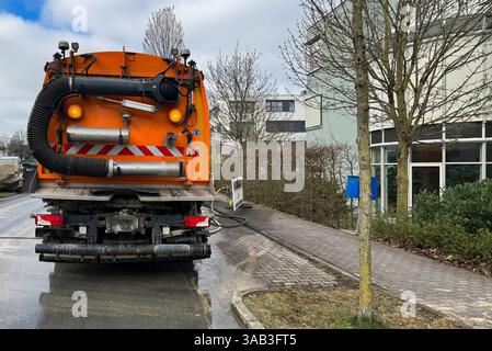 Un camion de lavage de rue tire l'eau d'une bouche d'incendie de ville. Vue arrière du véhicule debout sur la chaussée d'une rue de ville. Banque D'Images