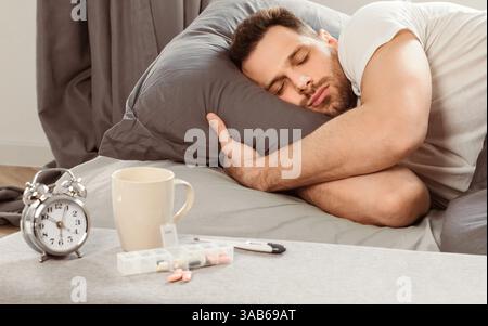 Malade Homme endormi ayant de la fièvre couché dans le lit à la maison Banque D'Images