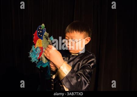 Un interprète prépare sa marionnette pour la prochaine représentation. L'art de la marionnette d'ombre en Chine remonte à la dynastie Han au IIIe siècle. Banque D'Images