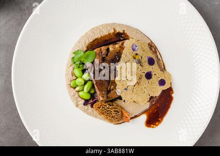Assiette gourmande de viande cuite lentement, morilles, purée et tuile Banque D'Images