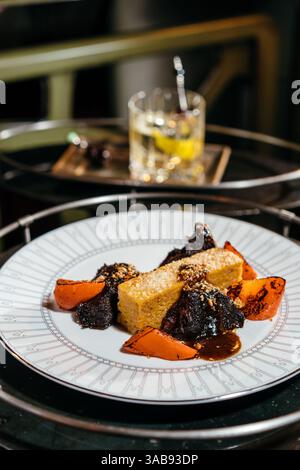 Un plat gastronomique composé de tendres joues de veau braisées, servi avec une polenta crémeuse. Parfaitement garni de légumes vibrants pour un dini luxueux Banque D'Images