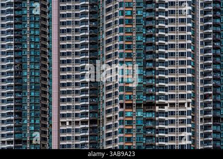 Une photographie architecturale saisissante capturant la façade dense et détaillée des immeubles résidentiels modernes de grande hauteur à Hong Kong, mettant en valeur un vari Banque D'Images