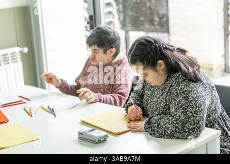 Deux personnes dans une résidence de santé mentale se livrent à des activités créatives. L'un est l'écriture et l'autre le dessin, favorisant un soutien et nourrissant Banque D'Images