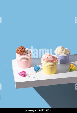 Une dose vibrante de tasses de crème glacée au chocolat, à la fraise et à la vanille avec des décorations. Un éclairage doux et aéré améliore les textures. Banque D'Images