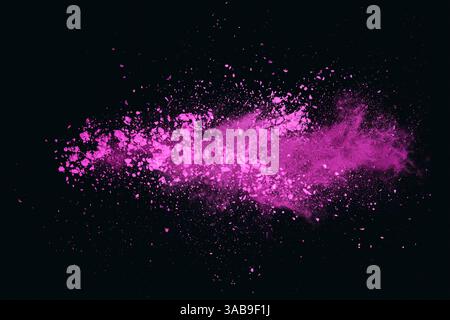 Un nuage vibrant de poussière de couleur rose flotte à travers un fond noir, créant un contraste visuellement fascinant avec des teintes intenses de fuchsia et de m Banque D'Images