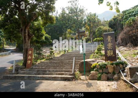 Vue de l'escalier menant à l'entrée du monastère de Tsing Shan. Tuen Mun, Hong Kong ; avril 2025. Banque D'Images