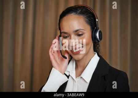 Représentant professionnel du service clientèle portant Un casque, souriant tout en aidant les clients Banque D'Images