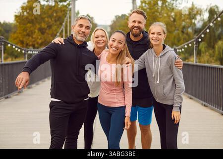 Heureux sportifs embrassant et regardant gai la caméra après un entraînement dans la nature. Banque D'Images