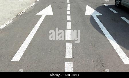 Des flèches clairement marquées guident la circulation sur une route urbaine Banque D'Images