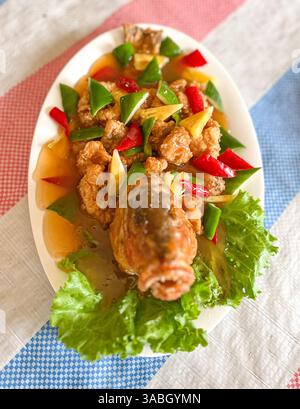 poisson entier croustillant frit avec des légumes dans une sauce aigre-douce Banque D'Images