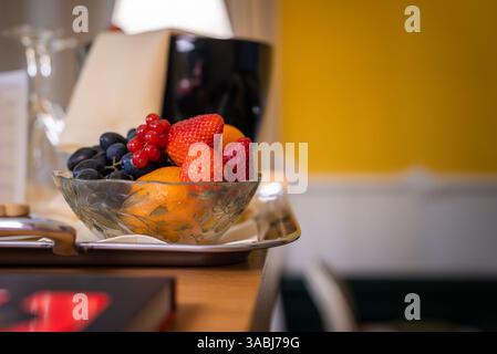 Bol en verre de fruits frais sur plateau argenté dans un cadre intérieur confortable Banque D'Images