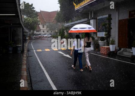 BANGKOK, THAÏLANDE , OCTOBRE 2021 personnes sous la pluie à Wat Saket Ratchawora. Crédits : Daniel Rodrigues Banque D'Images