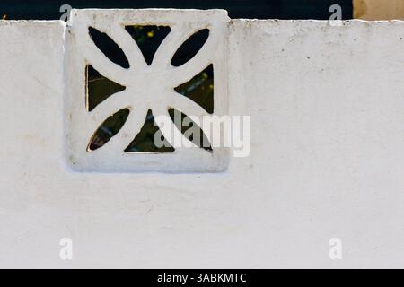Motif décoratif sur un mur de stuc blanc à la lumière du soleil Banque D'Images