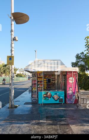 Crète. Grèce - 02 avril 2025 : kiosque de rue dynamique vendant des collations, des boissons et des glaces, avec une canopée ombragée et un cadre urbain animé avec p Banque D'Images